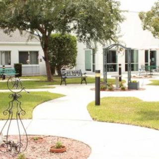 A serene garden with a winding pathway and benches surrounded by buildings.