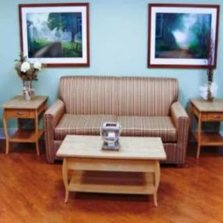 A cozy living room with a striped sofa, wooden coffee table, and side tables adorned with decorative items.