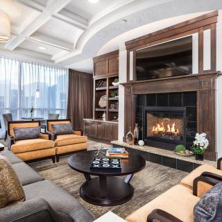 A luxurious and cozy living room featuring a fireplace, elegant furniture, and soft lighting.