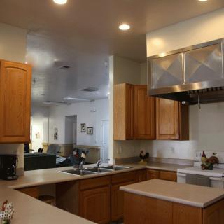 A modern kitchen with wooden cabinets, ample countertop space, and a stainless steel range hood.