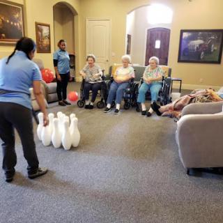 Seniors enjoying a fun bowling activity in an indoor setting.