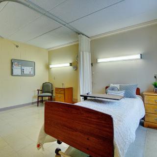 A well-lit hospital room featuring a bed and essential furnishings.
