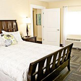 A cozy bedroom with wooden furniture and soft lighting.