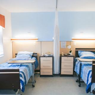 A shared patient room featuring two beds, designed for comfort and care.