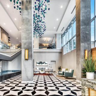 A luxurious and modern lobby with geometric flooring and elegant furnishings.