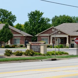 Suburban buildings with landscaped surroundings and street signage.