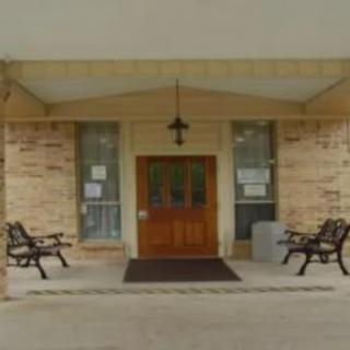 The entrance of a building with benches and a covered porch.