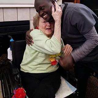A heartwarming moment between two people, one in a wheelchair, embracing with smiles.