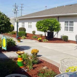A beautifully landscaped garden with a patio area, surrounded by shrubs and flowers.