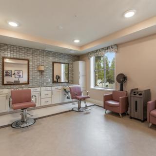 A modern salon interior featuring styling chairs and mirrors, with a warm and welcoming atmosphere.