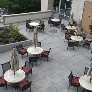 An outdoor patio with tables, chairs, and umbrellas set up for seating.