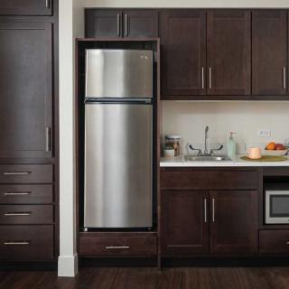 A modern kitchen with dark wood cabinets and a stainless steel refrigerator.