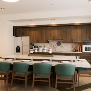 A contemporary kitchen featuring sleek wooden cabinets, marble countertops, and a cozy dining area.