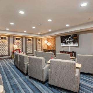 A modern lounge with comfortable seating and a large television.