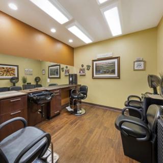 A well-lit barbershop interior featuring multiple chairs and mirrors.