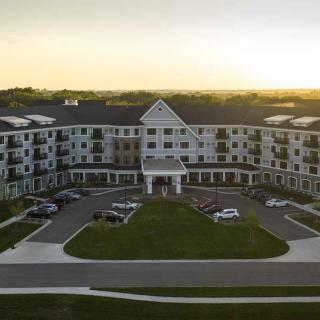 A residential building with a parking lot at sunset.