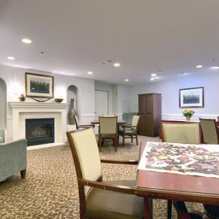 A cozy indoor room with seating areas, a fireplace, and decorative artwork.