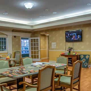 A cozy dining area with a table, chairs, and a wall-mounted television.