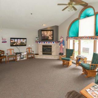 A spacious living room featuring a fireplace, comfortable seating, and large windows providing natural light.