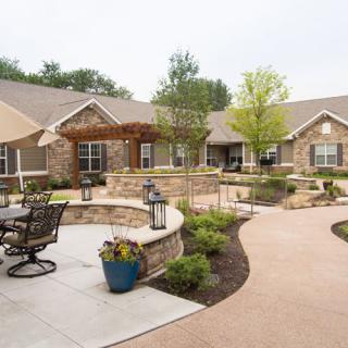 A beautifully landscaped garden with outdoor seating areas and a modern building in the background.