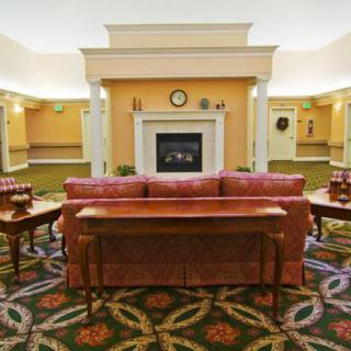 A cozy hotel lobby with a central fireplace and comfortable seating arrangement.