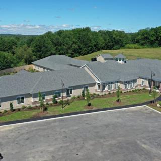 Aerial view of a large building surrounded by greenery and trees.
