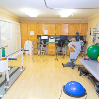 A well-equipped physical therapy room featuring various exercise machines and rehabilitation tools.
