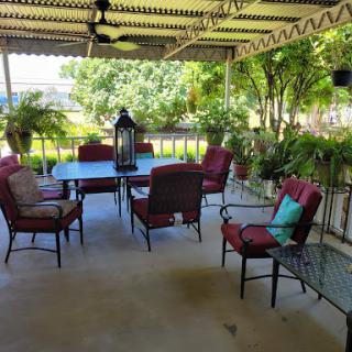 A serene outdoor patio setup with comfortable seating and lush greenery.