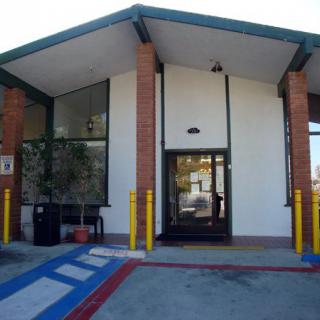 A building entrance with an accessible ramp and parking area.