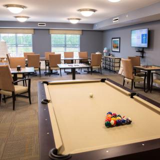 A spacious recreation room featuring a pool table and comfortable seating.