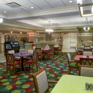 A colorful restaurant interior with tables and chairs arranged in a spacious dining area.