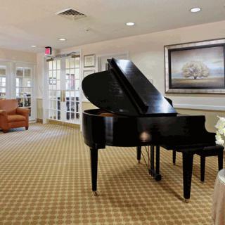 A cozy living room featuring a grand piano and comfortable seating.