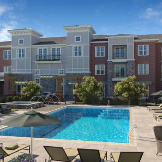 A modern apartment complex with a swimming pool and lounge area.