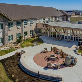 A modern building with a well-designed outdoor seating area featuring a fire pit.