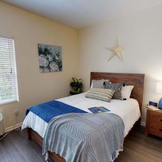A cozy bedroom with a neatly made bed, decorated with a blue and gray color scheme.
