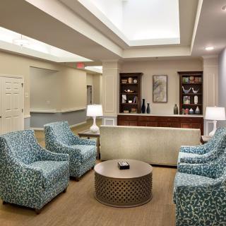 A stylish and comfortable waiting area with patterned armchairs and a central coffee table.