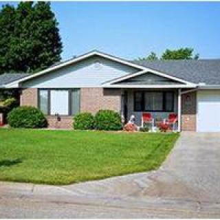A suburban house with a well-maintained lawn and porch.