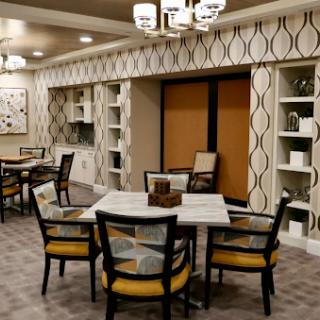 A modern dining area featuring stylish furniture and patterned walls, designed for a welcoming living space.