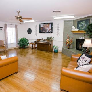 A spacious and inviting living room featuring warm wooden floors, comfortable seating, and a cozy fireplace.