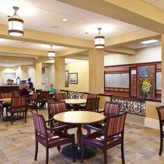 A cozy dining area with tables and chairs, featuring warm lighting.