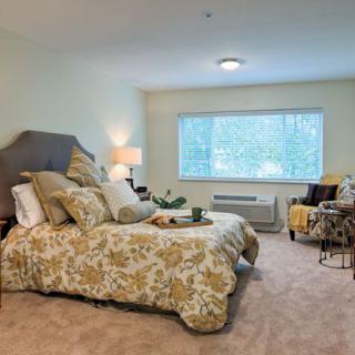 A cozy bedroom with elegant decor and large window.