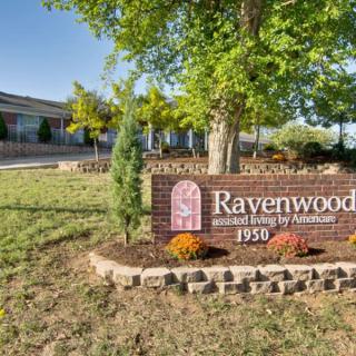 The entrance to Ravenwood Elementary School, showcasing a brick sign with nearby landscaping.