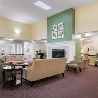 A modern living room with comfortable seating and a central fireplace.