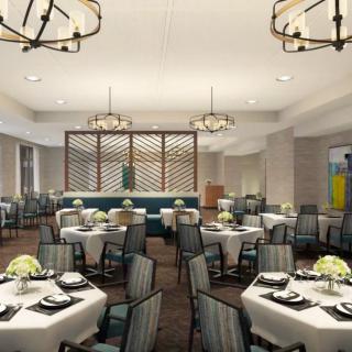 An elegant dining room setup with round tables and chairs, featuring stylish lighting and decor.