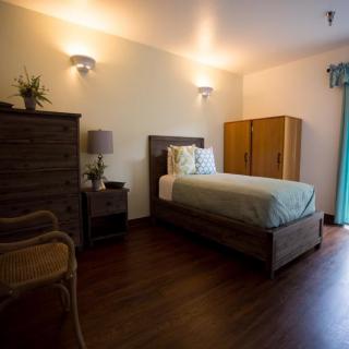 A cozy bedroom with a single bed and warm lighting.