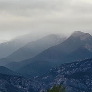 A serene view of mist-covered mountains under a cloudy sky.