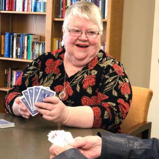 A person enjoying a card game in a library setting.