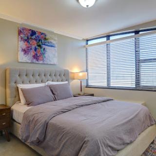 A cozy and modern bedroom featuring a comfortable bed, elegant decor, and natural light streaming in through the windows.
