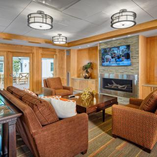 A cozy living room with modern decor, featuring a fireplace and comfortable seating.