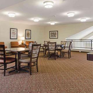 A cozy indoor seating area with tables and chairs, well-lit by ceiling lights.